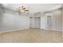 Open living room with neutral colors, tile flooring, and a decorative ceiling fan at 1101 Coral Desert Drive, Las Vegas, NV 89123