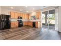 Efficient kitchen with wood cabinets, black appliances, and sliding glass doors to the backyard at 11273 Accademia Ct, Las Vegas, NV 89141