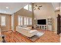 Vaulted living room featuring hardwood floors, a ceiling fan, and a modern entertainment center at 1908 Morro Vista Dr, Las Vegas, NV 89135