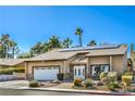 Cozy single-story home with desert landscaping, a two-car garage, and solar panels on the roof at 2233 Marlboro Dr, Henderson, NV 89014