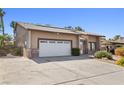 Single-story home features a two-car garage, brick accents, mature landscaping and a gated side entrance at 2233 Marlboro Dr, Henderson, NV 89014