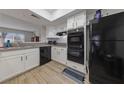 Bright kitchen featuring white cabinets and modern black appliances at 3630 Mckinley Ave, Las Vegas, NV 89121