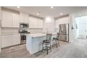 Modern, eat-in kitchen featuring white cabinets, stainless steel appliances, and an island with barstool seating at 4364 Contour Bend Ave, North Las Vegas, NV 89084