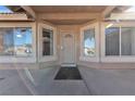 Inviting front porch features security door and neutral tones, with windows, creating a welcoming entrance to the home at 5841 Doubletree Rd, Pahrump, NV 89061