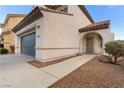 Charming stucco home with a two-car garage and arched entry, complemented by desert landscaping and a tiled roof at 8124 Loma Del Ray St, Las Vegas, NV 89131