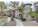 Inviting condominium with mature trees, desert landscaping and exterior stair access to upper units at 8250 N Grand Canyon Dr # 2059, Las Vegas, NV 89166