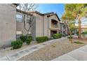 View of the condominium building showcasing landscaping and balcony access to upper units at 8250 N Grand Canyon Dr # 2059, Las Vegas, NV 89166