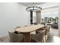 Elegant dining room with modern chandelier, seating for eight, and an open floorplan for easy entertaining at 8825-1 S Monte Cristo Way, Las Vegas, NV 89113