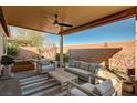 Inviting covered patio with comfortable seating and a ceiling fan, perfect for outdoor relaxation at 8856 Timber Mesa St, Las Vegas, NV 89139