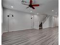 Bright living room boasts stylish gray wood floors and a modern ceiling fan for ultimate comfort at 1040 Via Panfilo Ave, Henderson, NV 89011