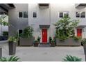 Welcoming entrance with red door, lush landscaping, and modern planters at 11441 Allerton Park Dr # 217, Las Vegas, NV 89135