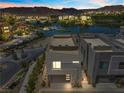 Dusk view of modern exterior with a lake view featuring stucco siding and a two-car garage at 14 Heron Harbour Dr, Henderson, NV 89011