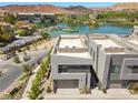 Modern exterior with a lake view featuring stucco siding and a two-car garage at 14 Heron Harbour Dr, Henderson, NV 89011