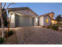 Home with a brick paver driveway leading to an attached two-car garage at 1544 Karst Pond Ave, North Las Vegas, NV 89084