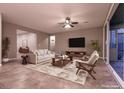 Bright living room featuring neutral tones, modern ceiling fan, and sliding glass door to patio at 1544 Karst Pond Ave, North Las Vegas, NV 89084