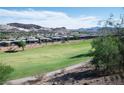 Scenic view of the green golf course and the neighboring homes against the desert mountains at 21 Via Visione # 201, Henderson, NV 89011