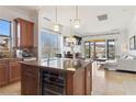 Open concept kitchen with stainless steel appliances, a center island, and a seamless living space at 21 Via Visione # 201, Henderson, NV 89011