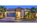 Inviting single-Gathering home featuring stone accents, a two-car garage, and professional landscaping at 24 Cliffwater St, Henderson, NV 89011