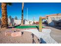 Spacious backyard featuring a putting green, desert landscaping, and a covered patio area at 3112 Hayden Ct, Las Vegas, NV 89134