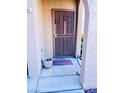 Close-up of condo entrance with secure screen door, welcome mat, and textured wall at 3845 Wiggins Bay St # 104, Las Vegas, NV 89129