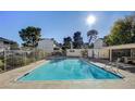 Community pool area with sunlit pool, shaded seating area, and white buildings at 4770 Topaz St # 31, Las Vegas, NV 89121