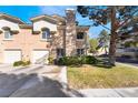 Two-story townhouse featuring a garage, inviting curb appeal, and manicured lawn at 502 Fragrant Orchard St, Henderson, NV 89015