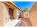 Side view of a home with a front door, window, block fence and desert landscaping at 6028 Stern Cove Ct, North Las Vegas, NV 89031