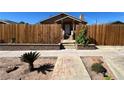 Landscaped front yard with a paved walkway leading to the cozy stone home at 628 Avenue L, Boulder City, NV 89005