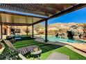 Stunning backyard with a sparkling pool, rock waterfall, artificial turf, covered patio, and comfortable lounge seating at 6689 Sparks Ave, Las Vegas, NV 89142