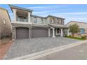 Elegant two-story home with brick accents, covered entrance, three-car garage, and beautifully paved driveway at 7153 Grace Estate Ave, Las Vegas, NV 89113