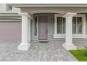 Inviting front porch featuring stately columns, neutral colors and a stone-paved walkway, creating a welcoming entrance at 7153 Grace Estate Ave, Las Vegas, NV 89113