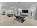 Spacious living room features a modern fireplace, a sleek pool table, and abundant natural light at 7153 Grace Estate Ave, Las Vegas, NV 89113