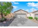 Beautiful single-story home with mature landscaping and a spacious driveway leading to a two-car garage at 7633 Lily Trotter St, North Las Vegas, NV 89084