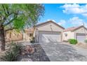 Charming single-story home featuring a well-maintained front yard with low-maintenance landscaping and attached two-car garage at 7633 Lily Trotter St, North Las Vegas, NV 89084