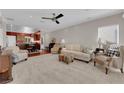 Bright living room features plush carpet, neutral paint, crown molding, a ceiling fan, and views of kitchen area at 7633 Lily Trotter St, North Las Vegas, NV 89084