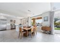 An open dining area and kitchen with stainless appliances, a center island, and seamless access to the backyard at 7999 Pinnacle Peak Ave, Las Vegas, NV 89113