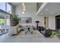 Well-lit living room with high ceilings, neutral decor, and access to the backyard at 7999 Pinnacle Peak Ave, Las Vegas, NV 89113