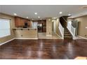 Open-concept living area with hardwood floors leading to the kitchen and a staircase at 8683 Bella Jewel Ave, Las Vegas, NV 89178