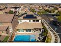 Aerial view of the home featuring a pool, outdoor seating area, and solar panels at 9519 Chandler Springs Ave, Las Vegas, NV 89148