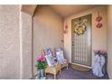 Inviting porch with seating, flowers, and a decorative wreath on the front door at 9655 Shadow Cliff Ave, Las Vegas, NV 89166