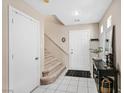 Bright entryway with tiled floors, a staircase, and a decorative console table at 9972 Trailing Vine St, Las Vegas, NV 89183