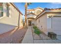 Charming front entrance with a tiled roof, desert landscaping, and a decorative front door at 9972 Trailing Vine St, Las Vegas, NV 89183