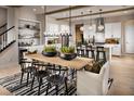 Open-concept dining area with stylish lighting, modern decor, and a view of the adjacent kitchen and island at 10131 Sequoia Glen Ave, Las Vegas, NV 89166