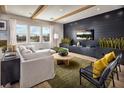 Bright and airy living room with modern furniture, wood floors, and a black accent wall with built-in shelving at 10131 Sequoia Glen Ave, Las Vegas, NV 89166