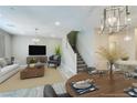 Spacious living room with a cozy seating arrangement, a modern entertainment center, and a dining area with a well-set table at 11396 Ogden Mills Dr # 101, Las Vegas, NV 89135