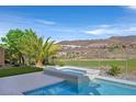 Relaxing backyard featuring a hot tub, professional landscaping, and a view of the surrounding mountains at 1320 Enchanted River Dr, Henderson, NV 89012