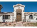 Detailed view of the arched front entrance with double doors, lion statues, and manicured desert landscaping at 1831 Rosemere Ct, Las Vegas, NV 89117