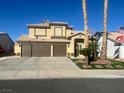 Inviting two-story home with a spacious driveway and a well-maintained front yard with lush landscaping and palm trees at 1913 April Mist St, Henderson, NV 89002