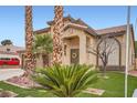Charming two-story home featuring a large driveway, a well-manicured lawn, and palm trees enhancing its curb appeal at 1913 April Mist St, Henderson, NV 89002