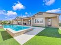 A backyard pool area with grass accents and a covered patio for outdoor relaxation at 380 Baratheon Ave, Las Vegas, NV 89183